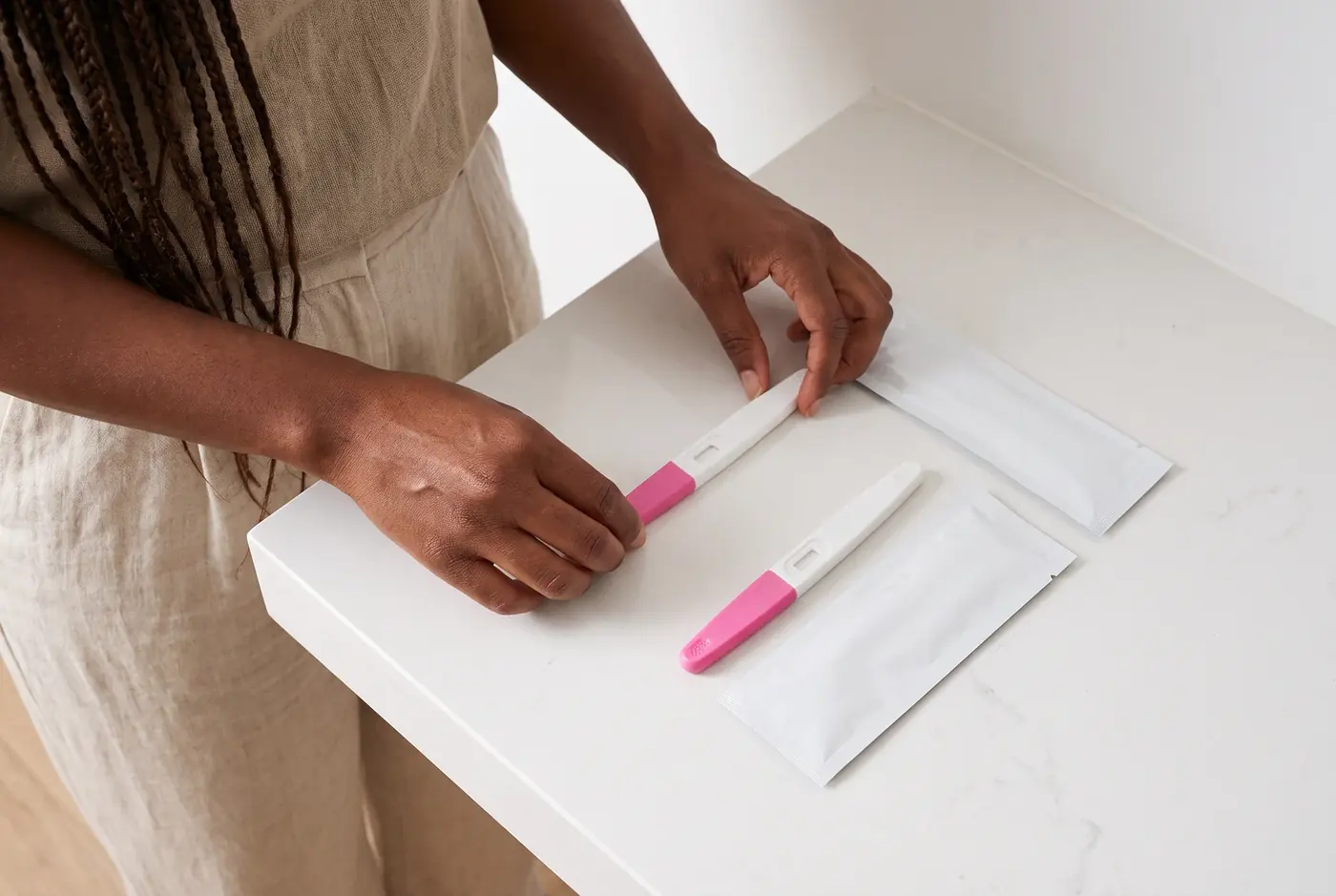 Two face-down pregnancy tests beside separate closed pouches