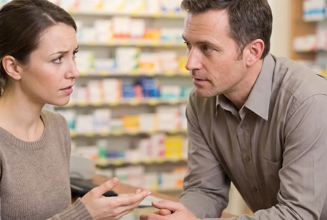 Woman speaking with a pharmacist at a counter